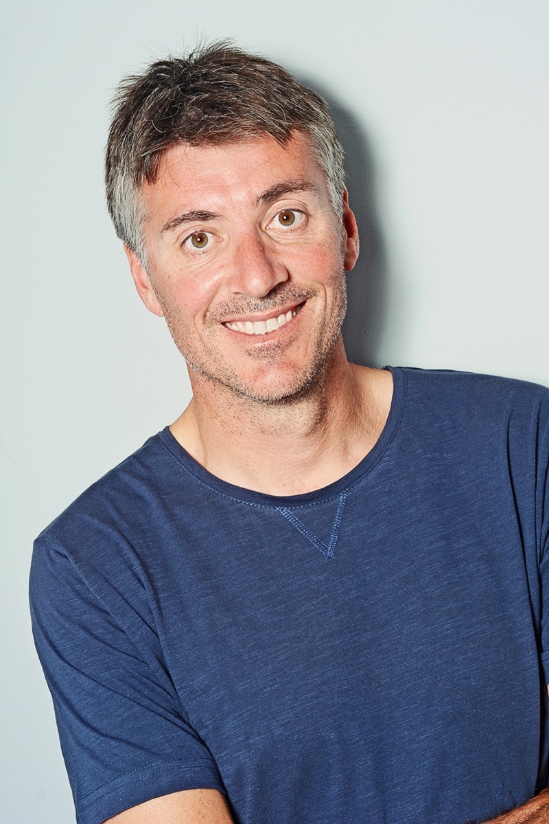 Photo of Gregg Dunnett in a blue t-shirt against a pale background.