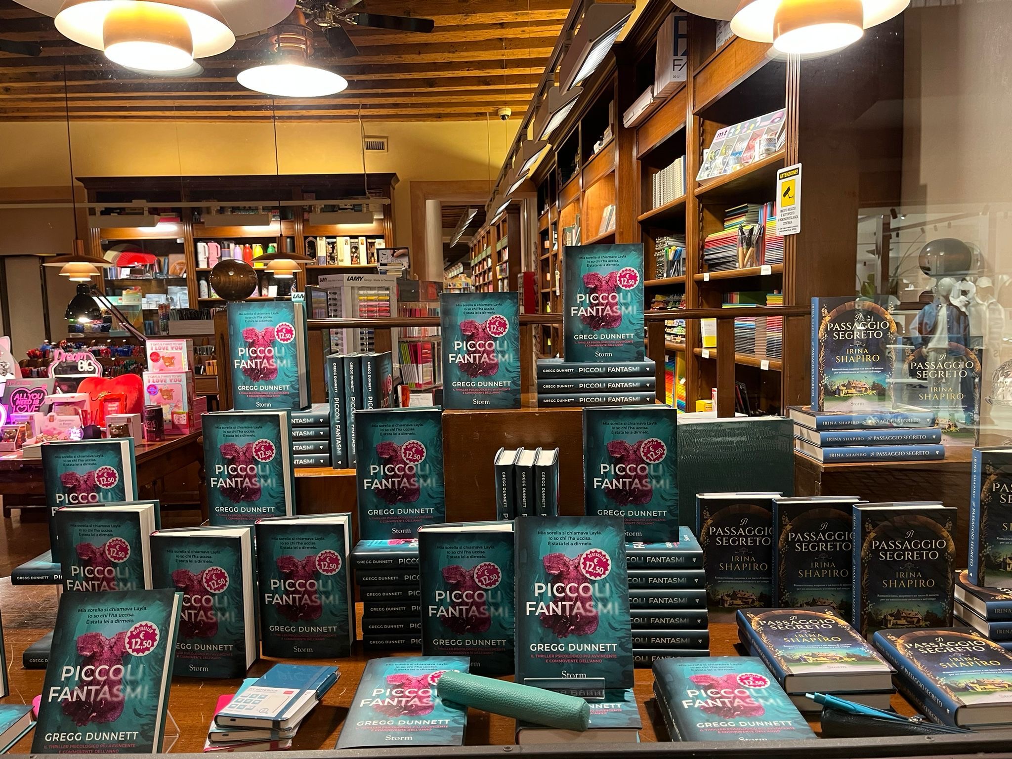 A bookshop window in Italy, stacked with copies of Piccoli Fantasmi — the Italian edition of Little Ghosts — alongside another author's book Il Passaggio Segreto.
